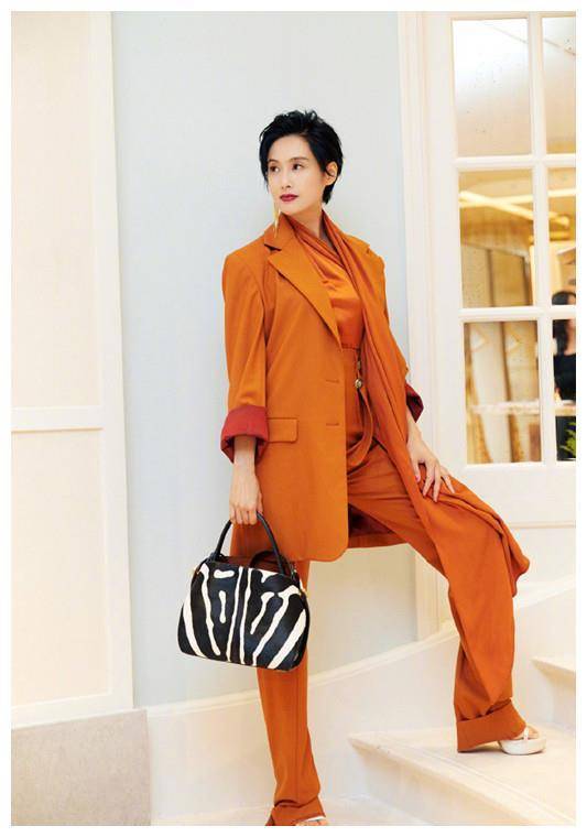 主人穿橙色正装,时尚氛围,高档,中长款正装大衣,休闲的氛围,宽腿长裤