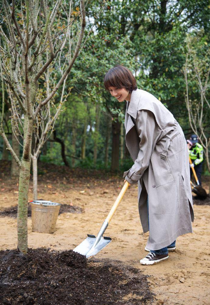 袁泉赴武汉樱花之约,穿大衣身材单薄似纸片,土堆里种树好接地气_风衣