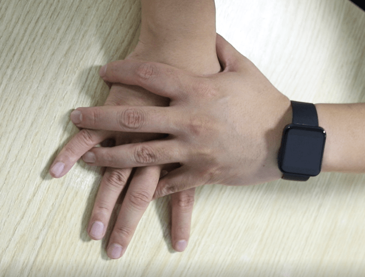 患者坐在桌子前,双手交叉平放在毛巾上,尽可能地将毛巾推向前方,通过