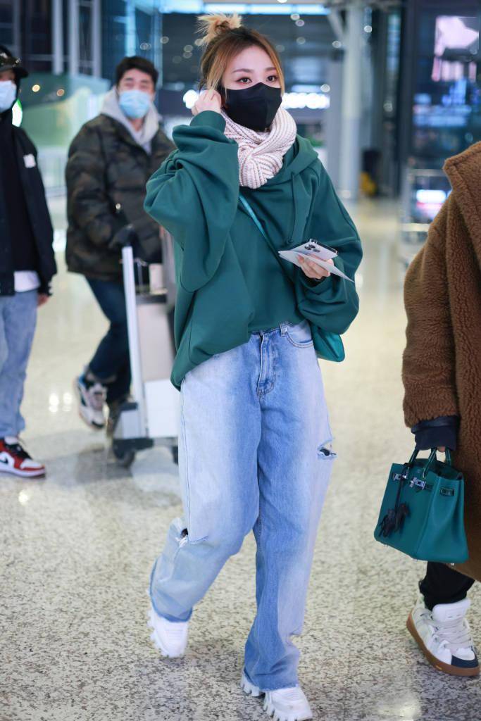 乃万身穿绿色宽版卫衣机场出行 系围巾搭破洞牛仔裤保暖又减龄_上海