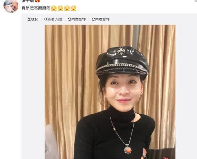 带着一个时髦的帽子,穿着打扮也非常的市场,张予曦妈妈坐在桌子前拍照