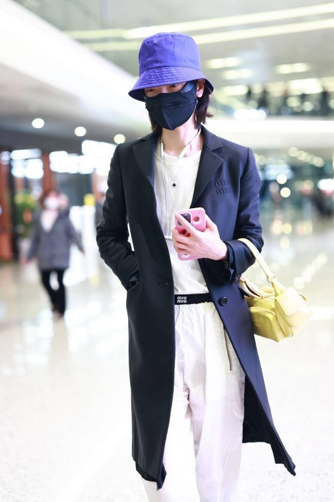 超模杜鹃现身上海机场 亮紫色渔夫帽配柠檬黄包包时尚度up!