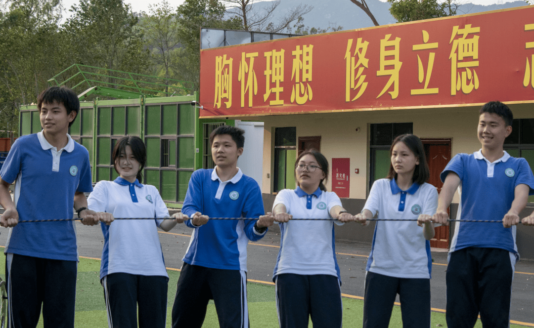蓝色白色校服相间着围坐一圈,长长的深绿绳索经过每一个同学的脚尖,在