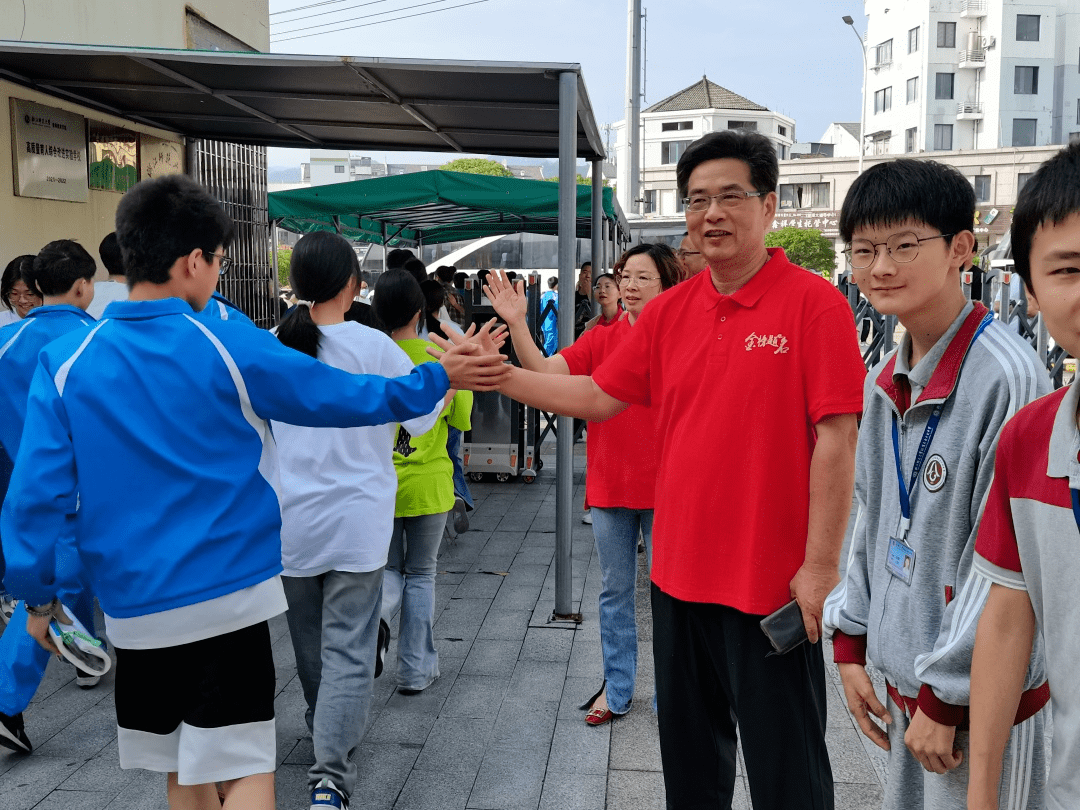 天台县赤城中学的教师身着红衣,用"红"运当头的好彩头将学子们送入