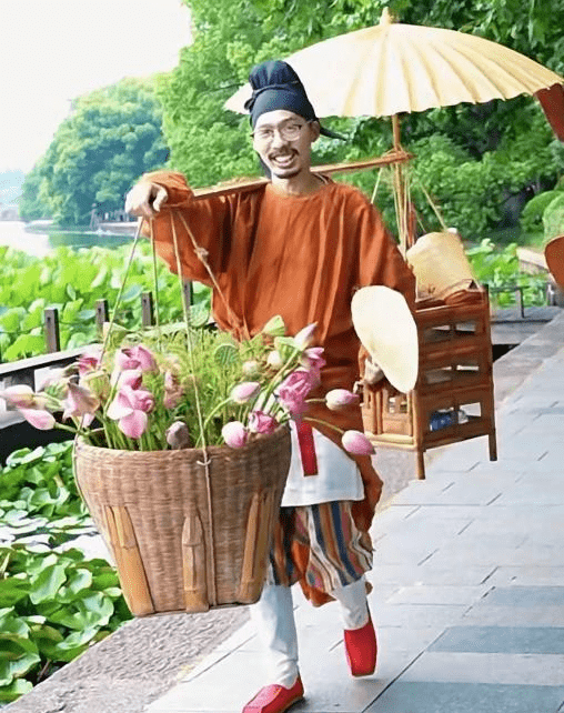 市集特邀定海版"网红"卖花郎穿越千年而来,挑着荷花在市集周边的东管