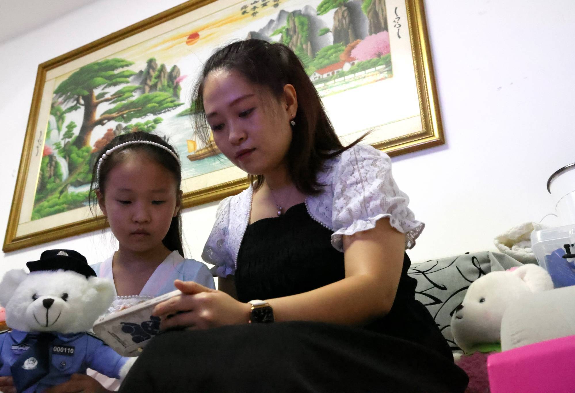 家长陪孩子看警察直播(齐红雨 摄)"现在每周四晚上七点半,已经成了