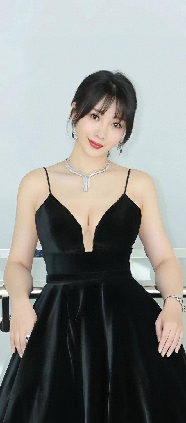 她身着深v吊带黑裙,就像一只优雅的黑天鹅
