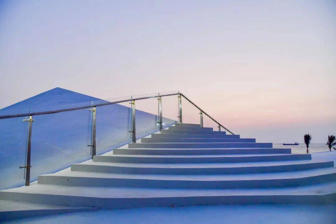 与蔚蓝的大海,金色的余晖相映成趣,巧妙相融,仿佛是一幅美妙的风景画