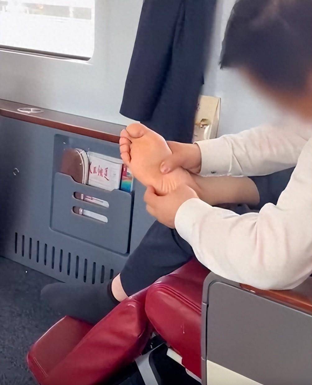 在高铁商务舱一男子的双脚都脱了鞋,一只脚还脱了袜子翘在腿上,并用