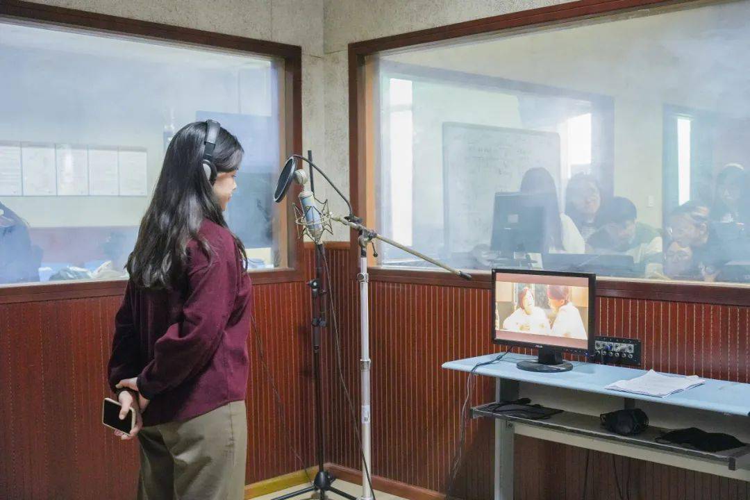 22级广编4班的杨婧为角色贾晓玲配音一面透明玻璃墙,连接起信号两端.