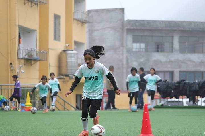 10月24日,貴州省畢節市大方縣元寶同心實驗學校女足隊員在練習帶球