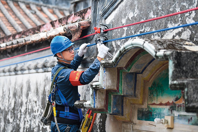 在汕頭市潮南區東華村,南方電網汕頭供電局工作人員正在進行線路安裝