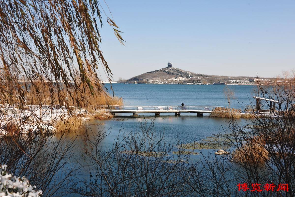 12月16日,淄博文昌湖湿地公园,湖面宁静如镜,映照着天空的蔚蓝和洁白