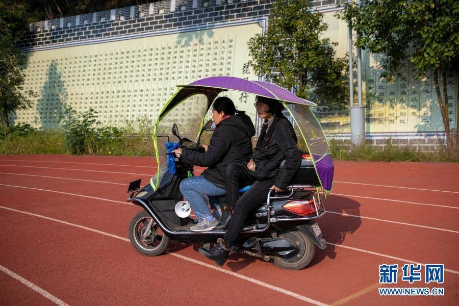 因為腿腳不便,張桂梅(後)坐車從田徑場回教學樓(11月30日攝).