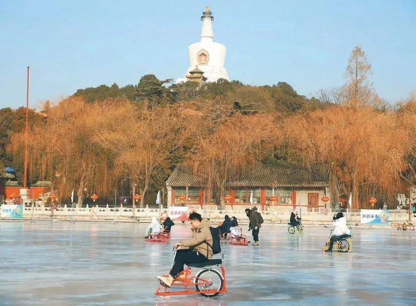 北海公園白塔前,遊客正在愉快地滑著冰車,騎著冰上自行車.