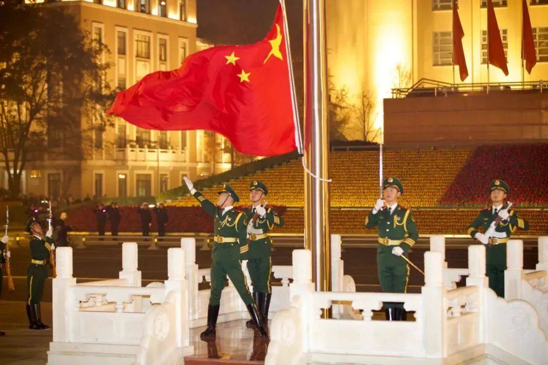缓缓升起鲜艳的五星红旗迎风飘扬升旗手将手中国旗的一角抛向空中伴随